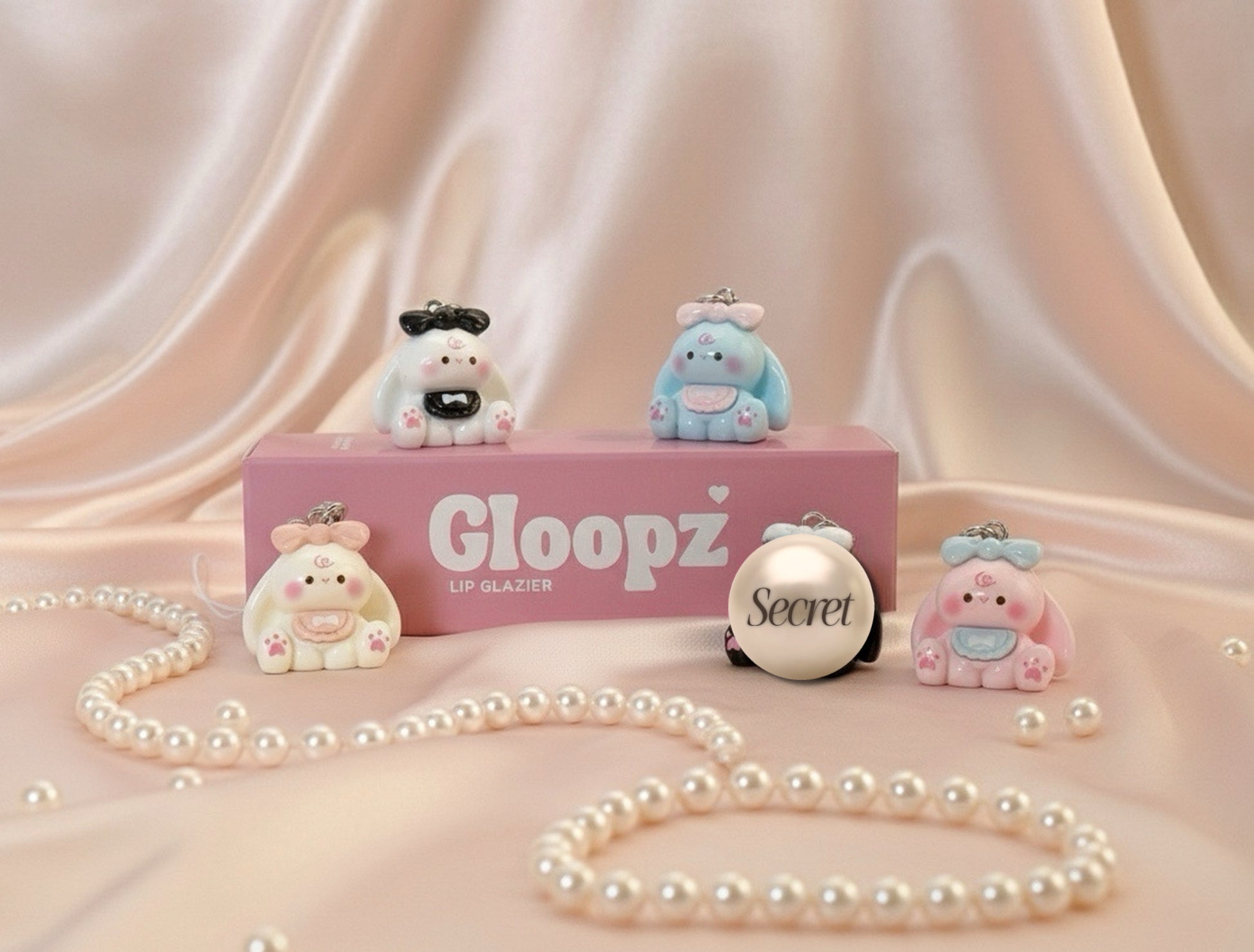 Gloopz lip glazier box decorated with bunny charms on a soft pink background