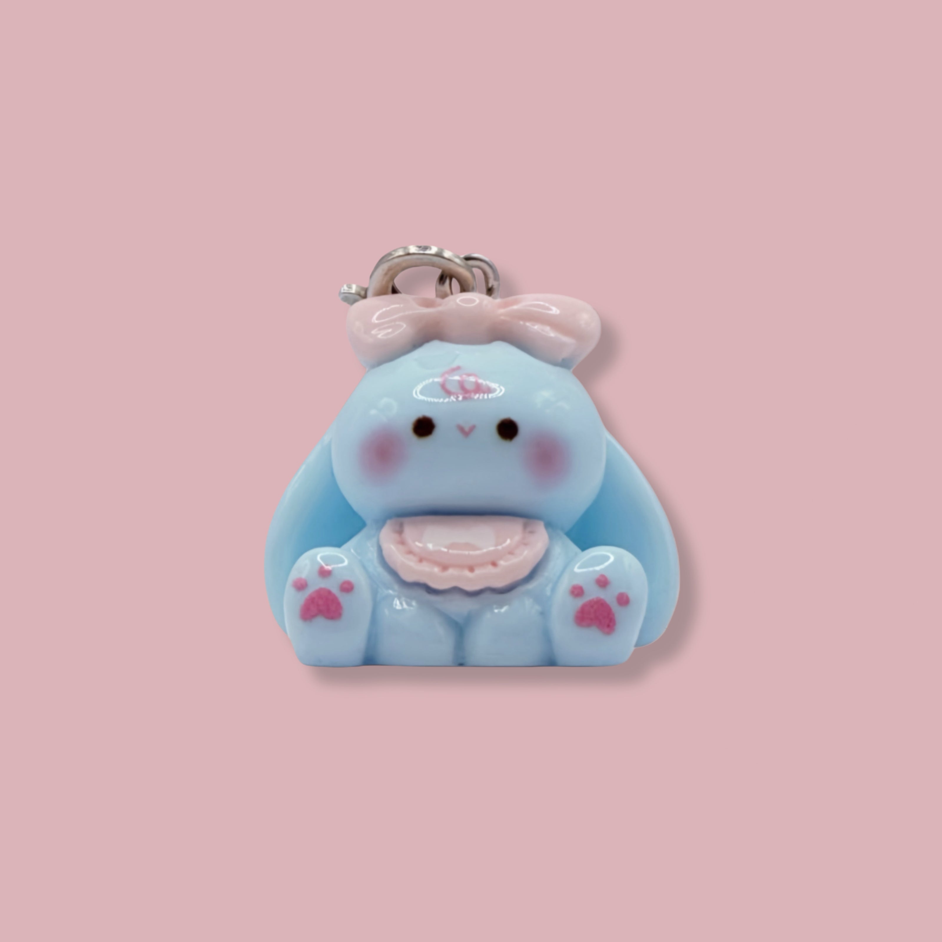 Cute blue bunny keychain with a bow on a pink background