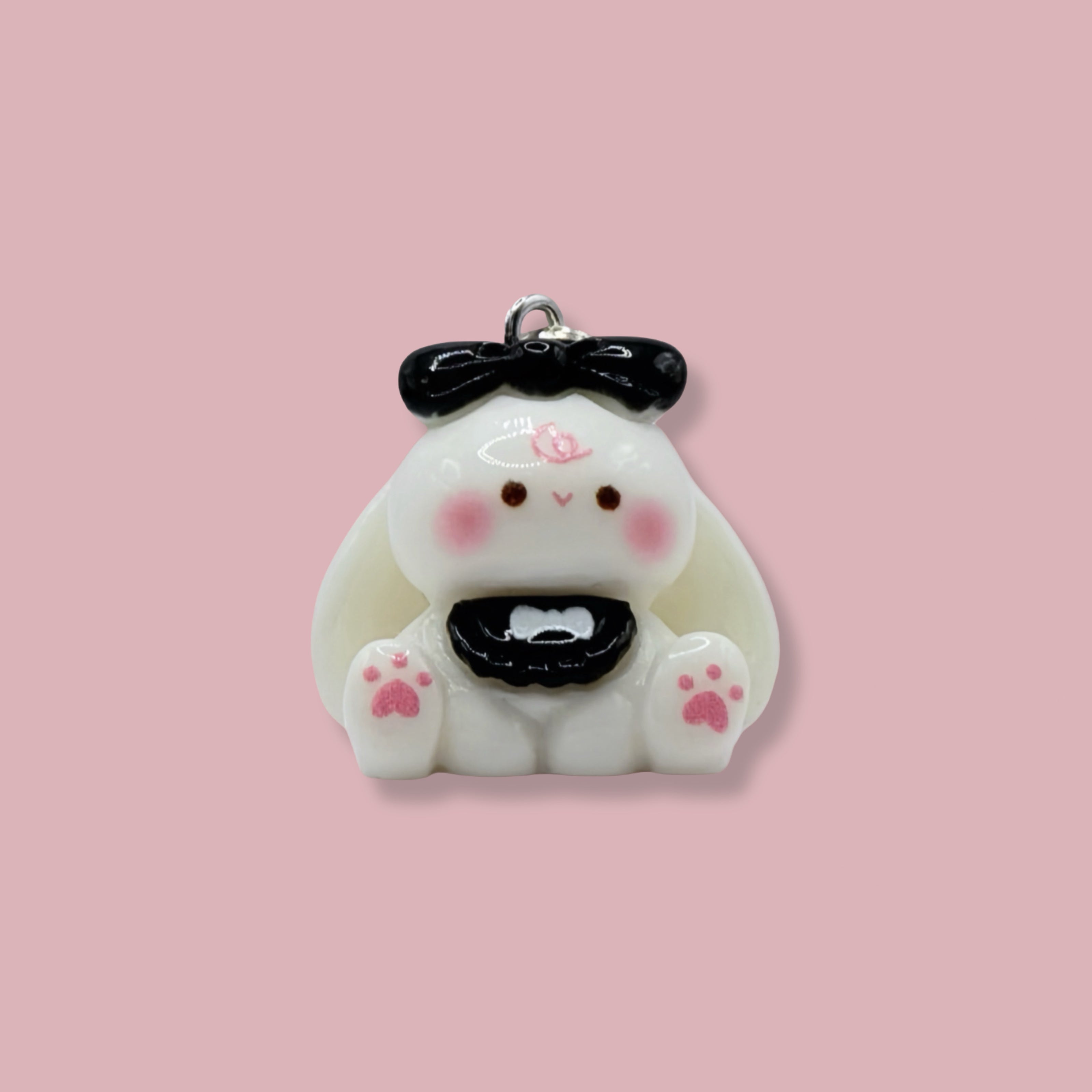 Cute bunny charm with a black bow on a pink background