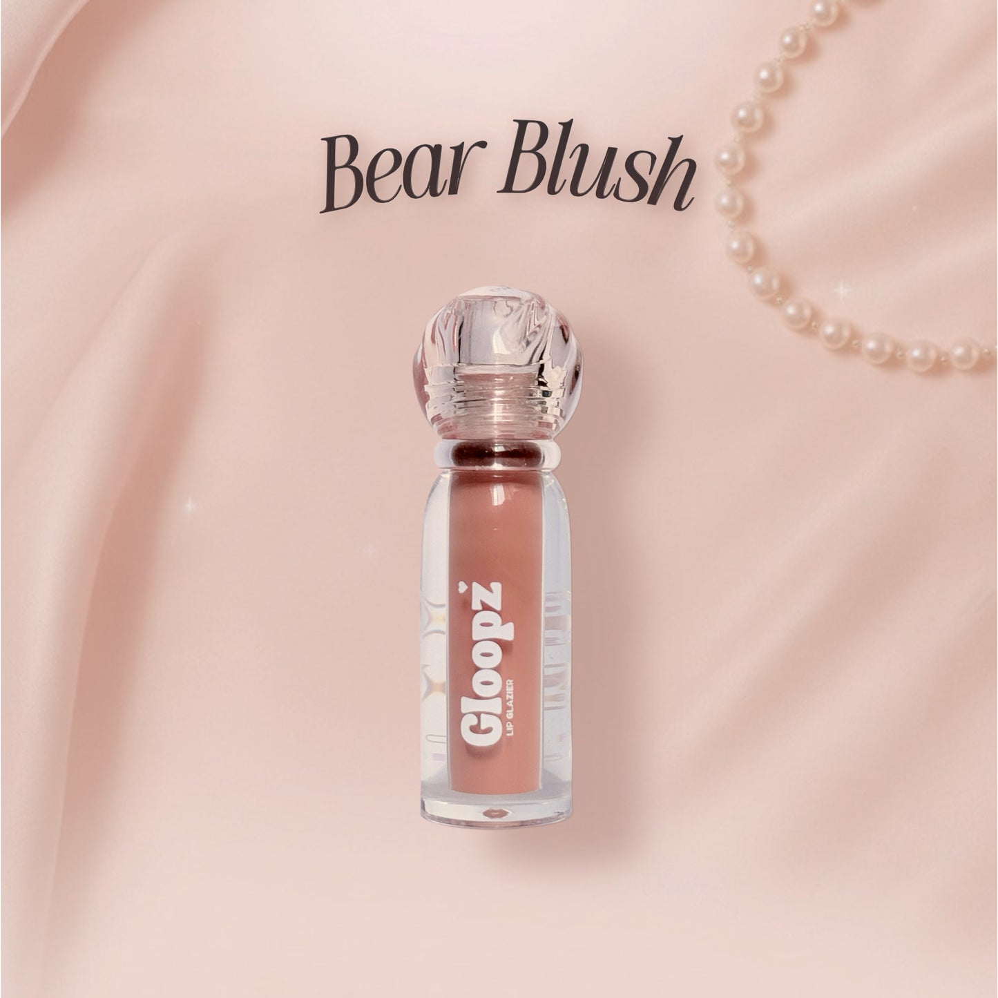 Gloopz Bear Blush lip gloss on a pink background with pearls