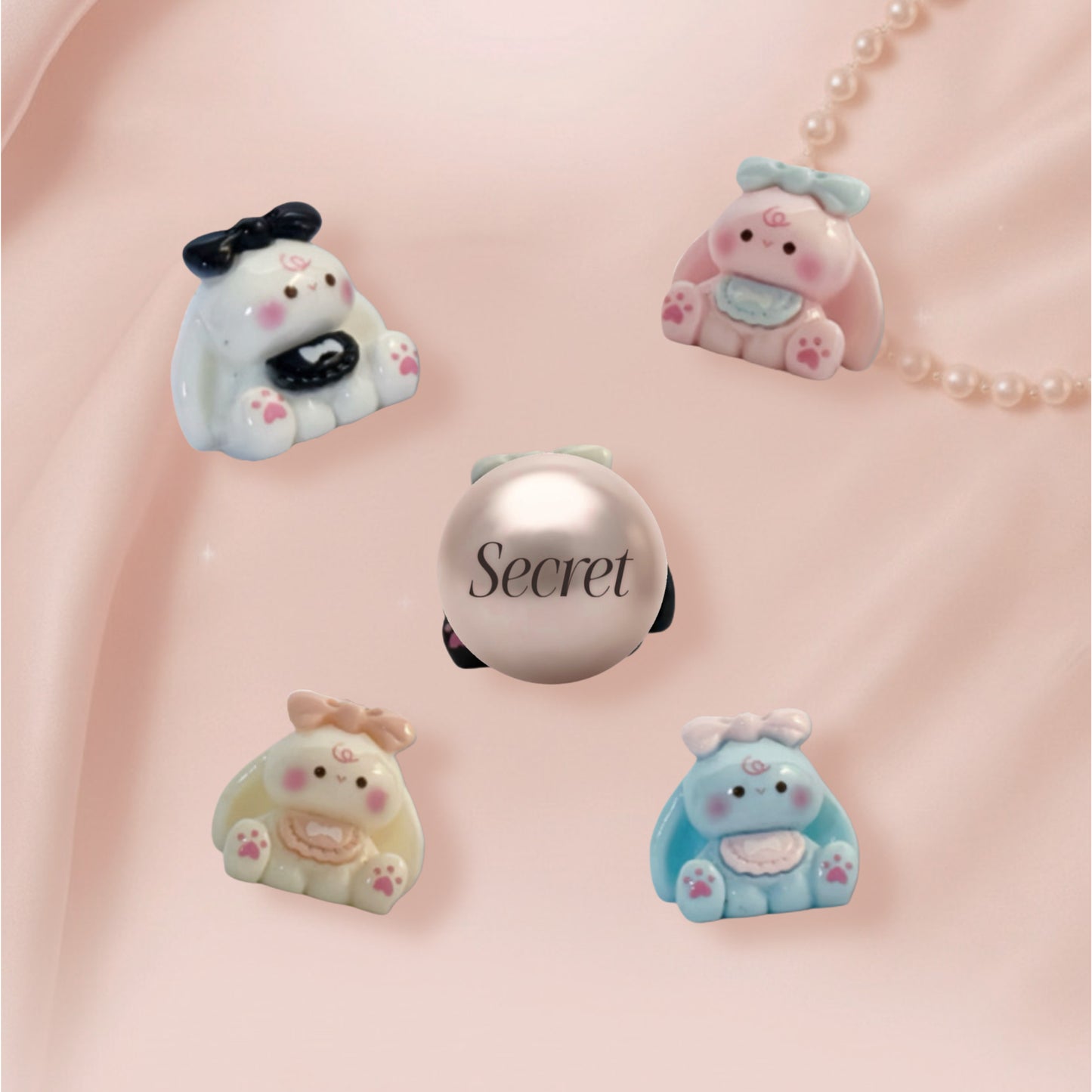 Set of cute bunny-shaped charms on a pink background