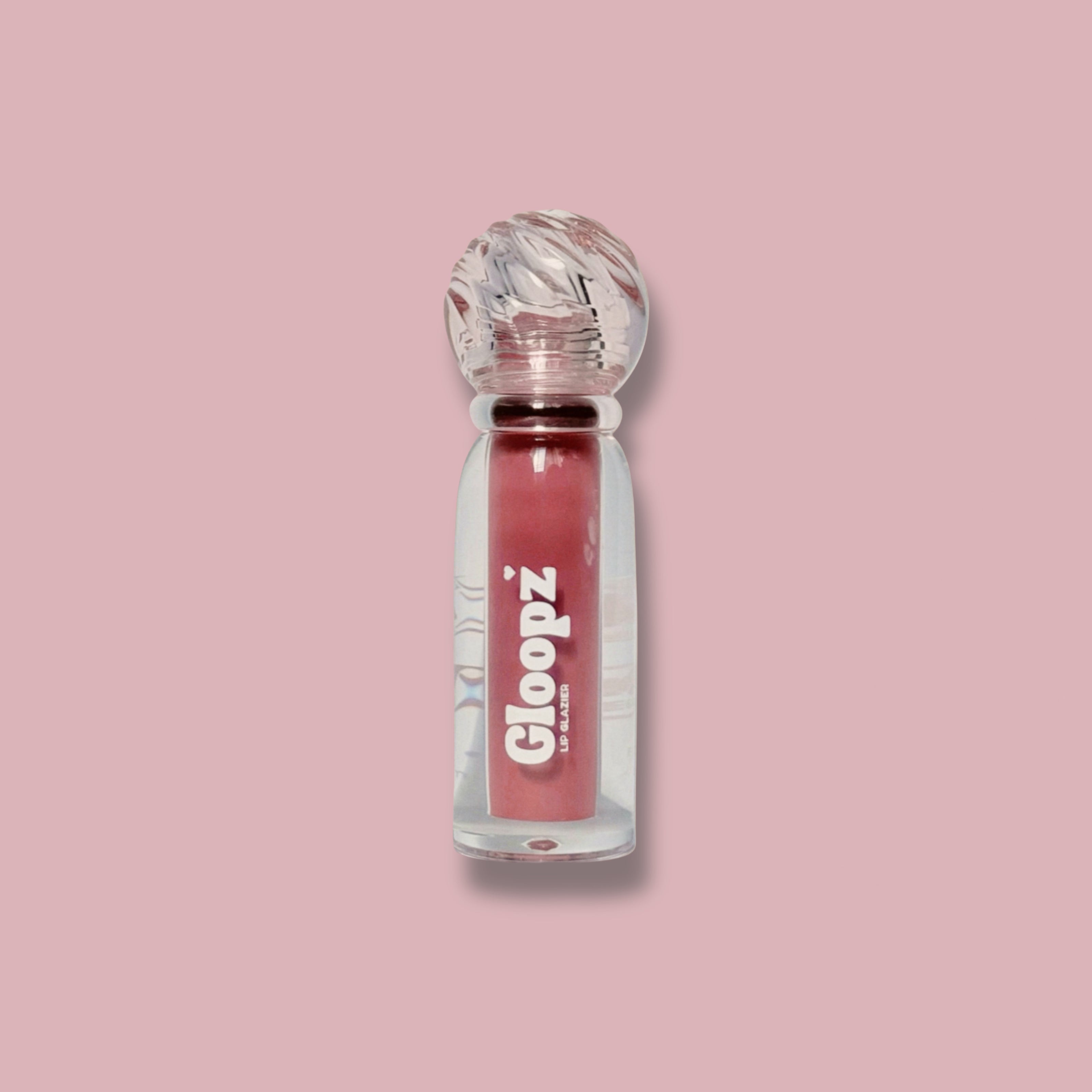 Gloopz lip gloss bottle on a pink background