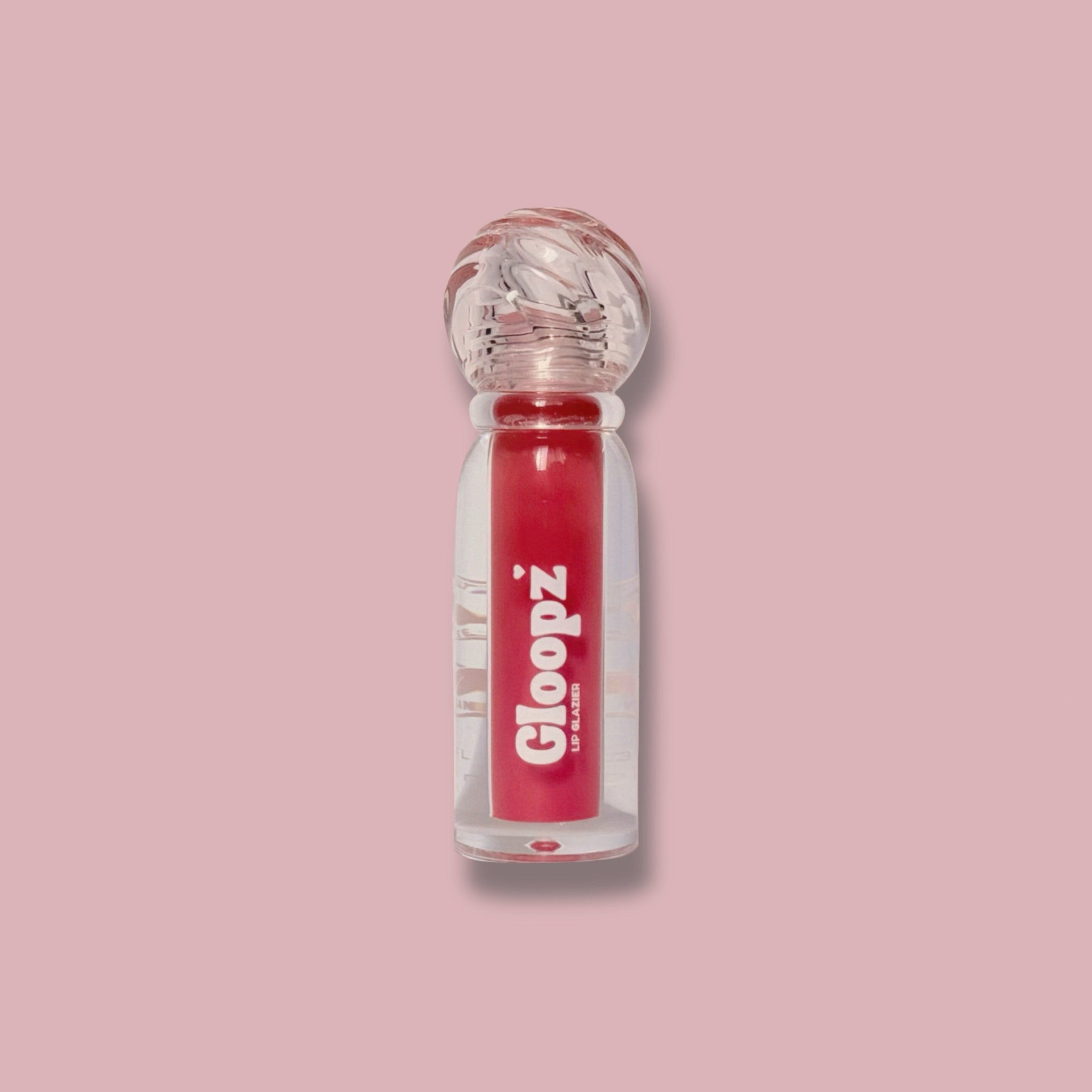 Lip gloss bottle with red liquid and clear cap on a pink background