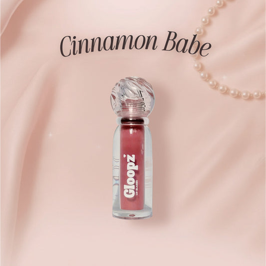 Gloopz lip gloss bottle with 'Cinnamon Babe' text on a pink background