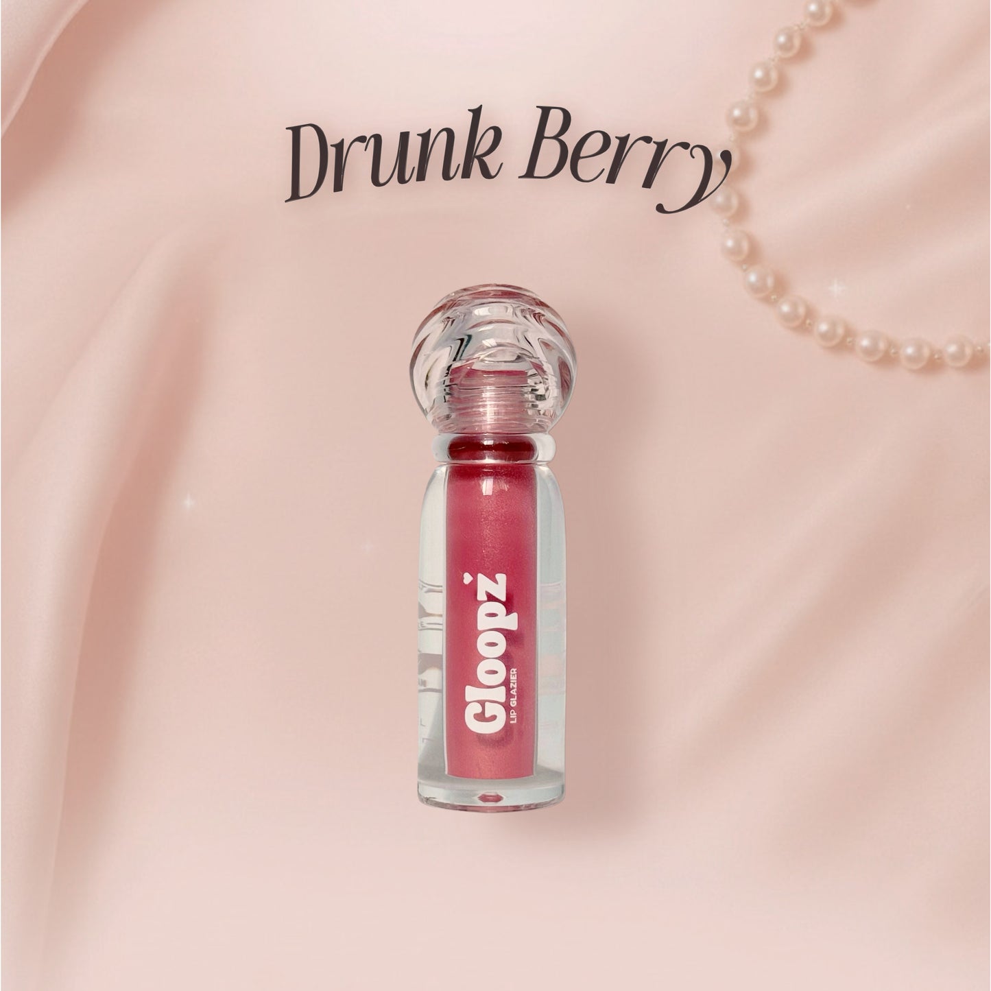 Pink lip gloss bottle with 'Drunk Berry' text on a pink background
