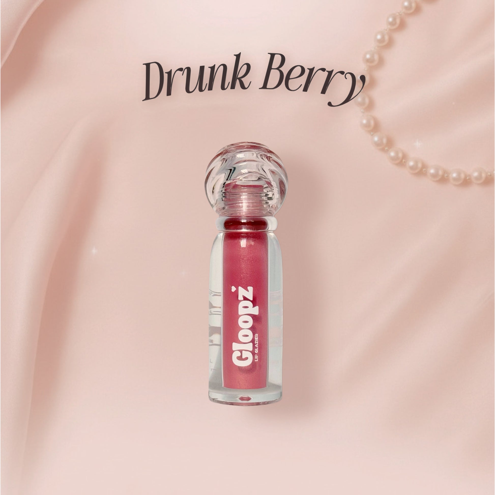 Pink lip gloss bottle with 'Drunk Berry' text on a pink background