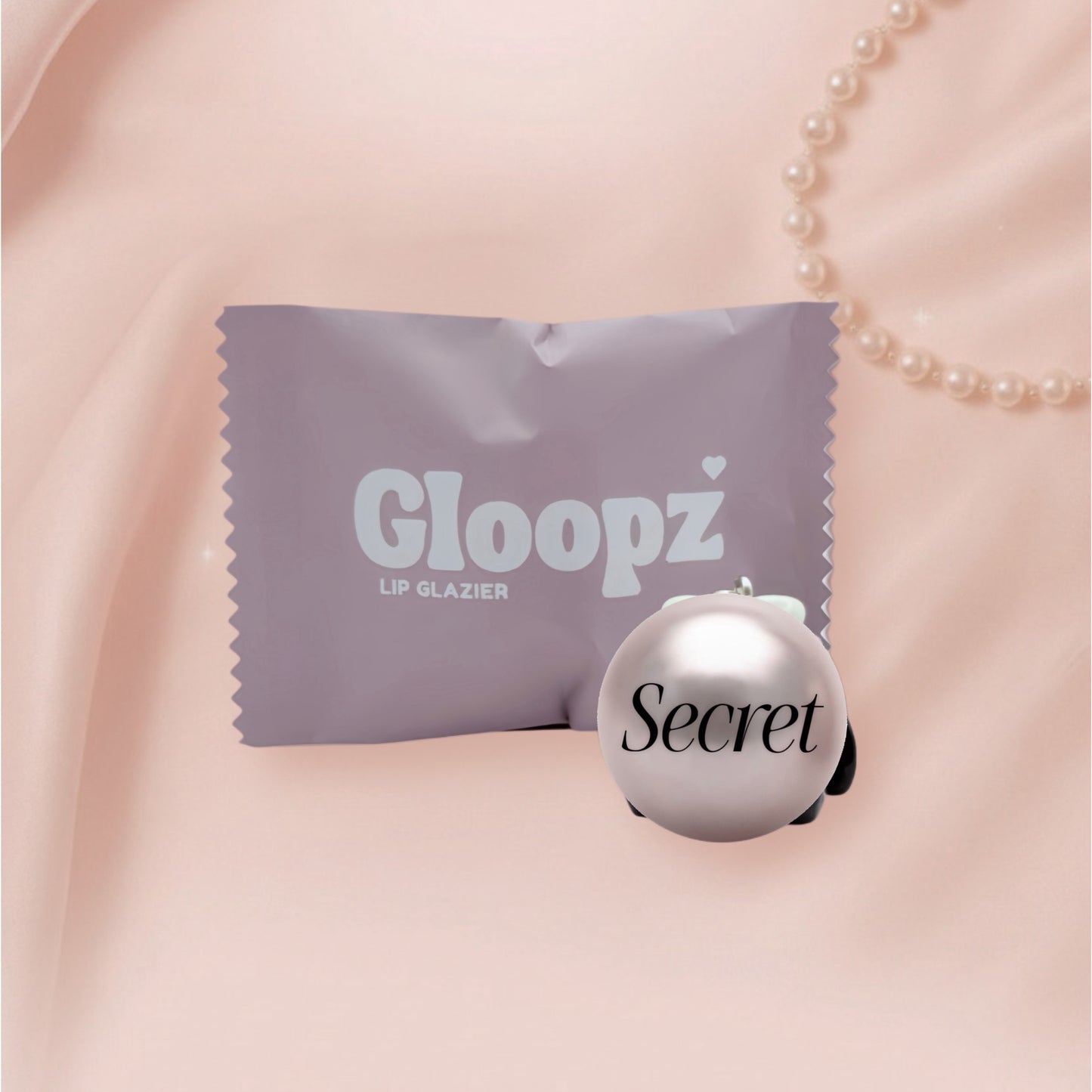 Gloopz lip glazier with packaging on a pink background