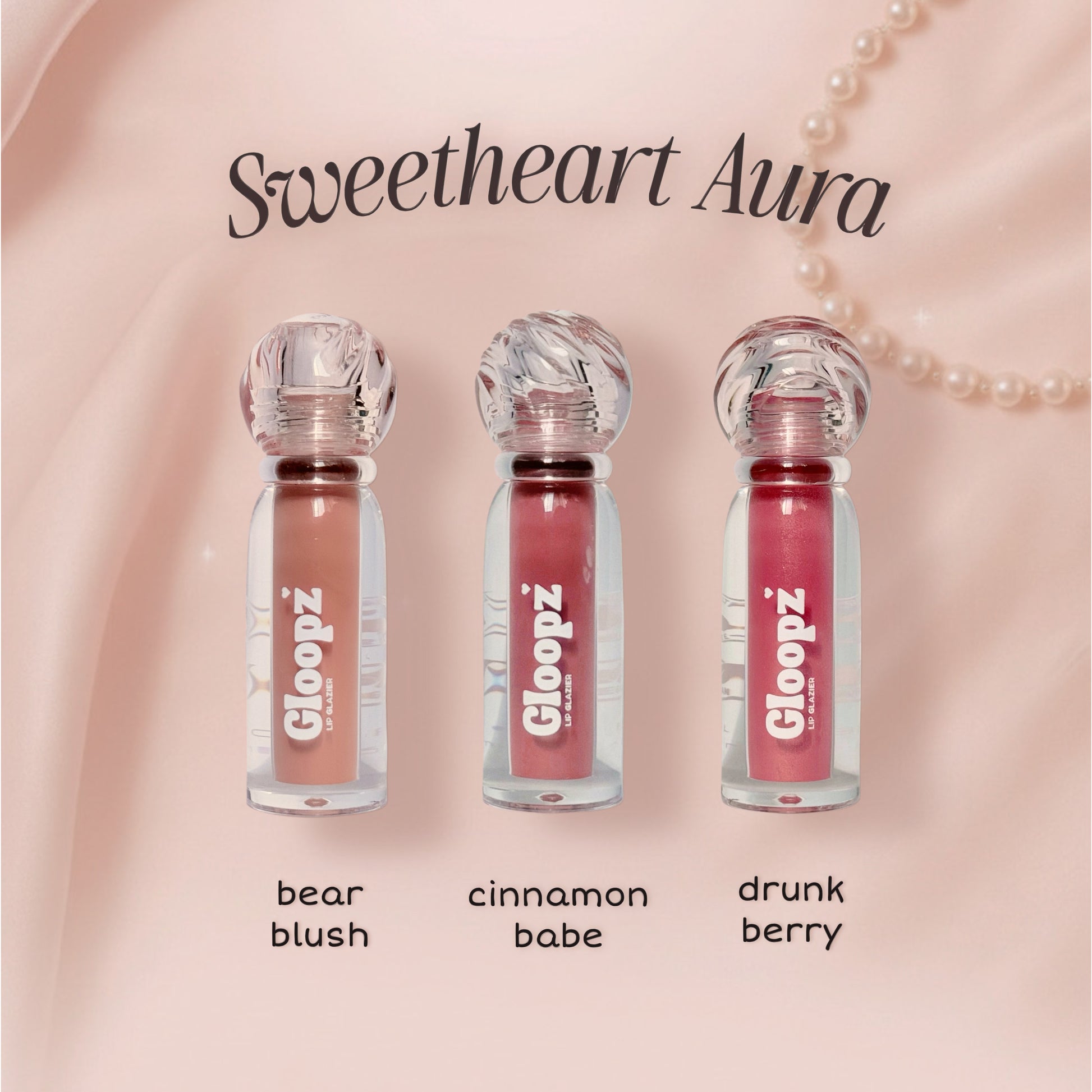 Three lip glosses from Gloopz with names 'bear blush', 'cinnamon babe', and 'drunk berry' on a pink background.